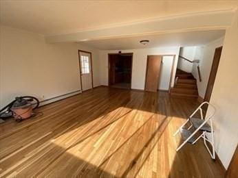 empty room featuring dark hardwood / wood-style flooring and a baseboard radiator