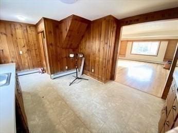 bonus room featuring a baseboard radiator and wood walls