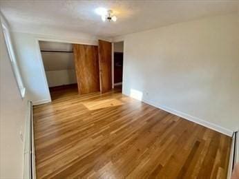 unfurnished bedroom featuring light hardwood / wood-style flooring and a closet