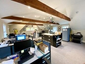 home office with light carpet and lofted ceiling with beams