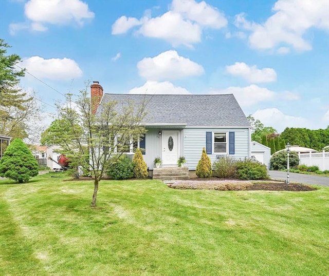 view of front of house with a chimney, a shingled roof, and a front lawn