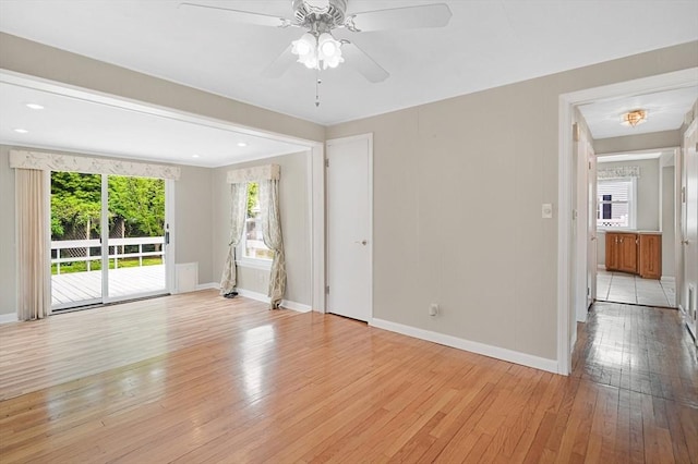 unfurnished living room featuring light wood-type flooring, baseboards, and a ceiling fan