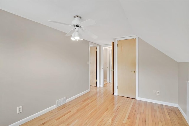 spare room featuring hardwood / wood-style flooring, a ceiling fan, baseboards, and lofted ceiling