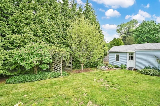 view of green lawn featuring an outbuilding