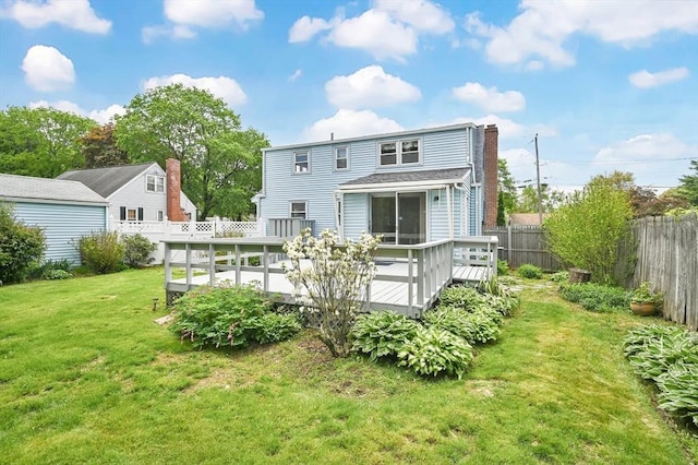 rear view of house with a deck and a chimney