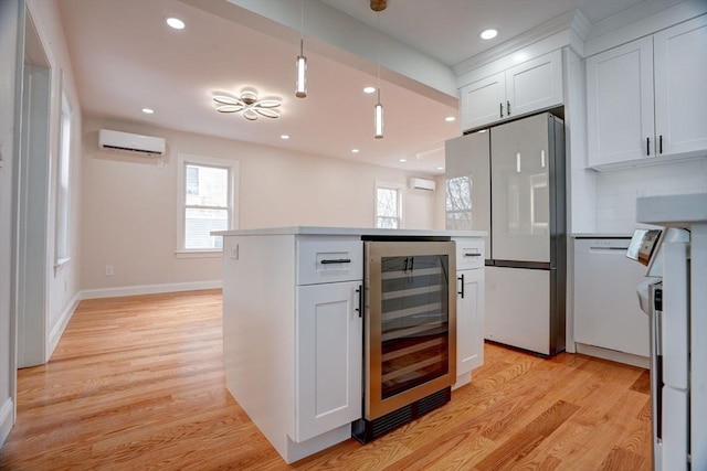 kitchen with white appliances, white cabinets, hanging light fixtures, a wall mounted AC, and beverage cooler