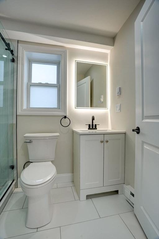 bathroom featuring tile patterned flooring, vanity, a shower with shower door, and toilet