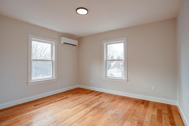 empty room featuring light hardwood / wood-style flooring and a wall mounted air conditioner