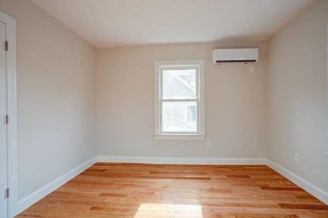 unfurnished room featuring light wood-type flooring and a wall unit AC