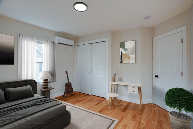 bedroom featuring a wall mounted AC, a closet, and wood-type flooring