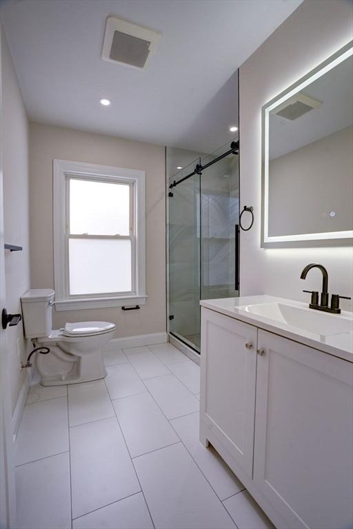 bathroom featuring an enclosed shower, vanity, toilet, and tile patterned flooring