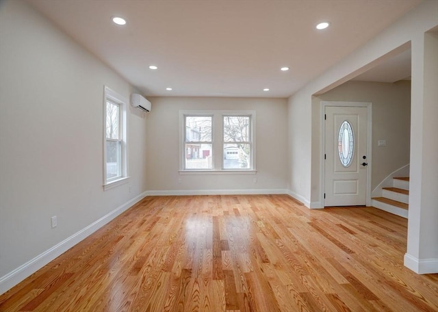 entrance foyer with light hardwood / wood-style floors and a wall unit AC