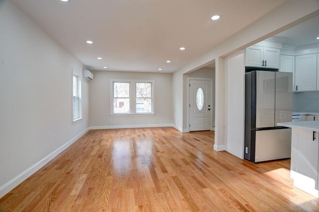 interior space featuring a wall unit AC and light hardwood / wood-style flooring