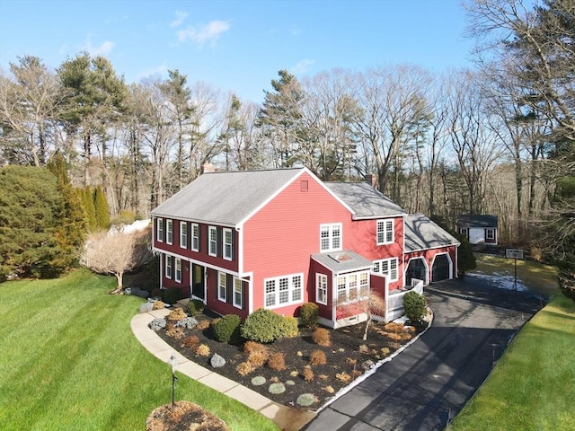 view of home's exterior featuring a garage, an outdoor structure, and a lawn