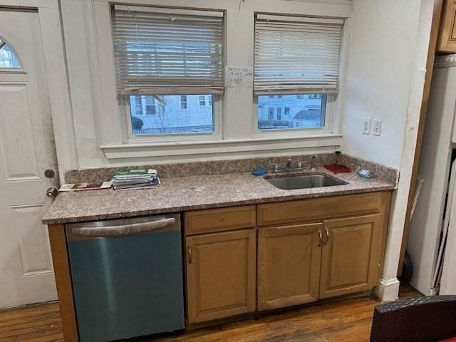 kitchen with stainless steel dishwasher, dark hardwood / wood-style floors, light stone countertops, and sink