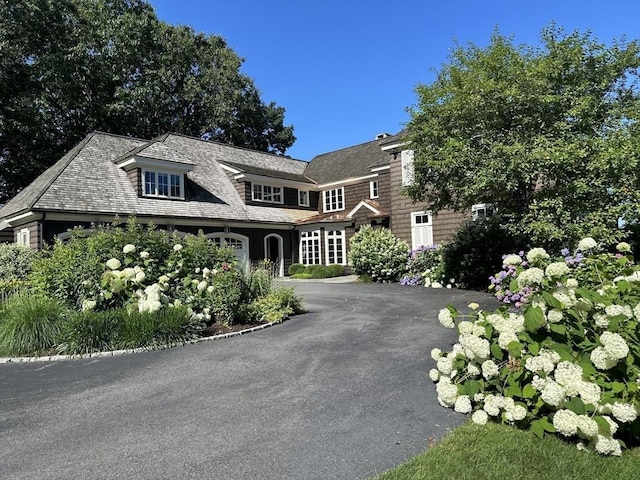 shingle-style home featuring aphalt driveway