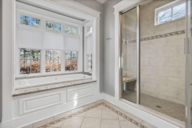 full bath with a bath, a shower stall, and baseboards