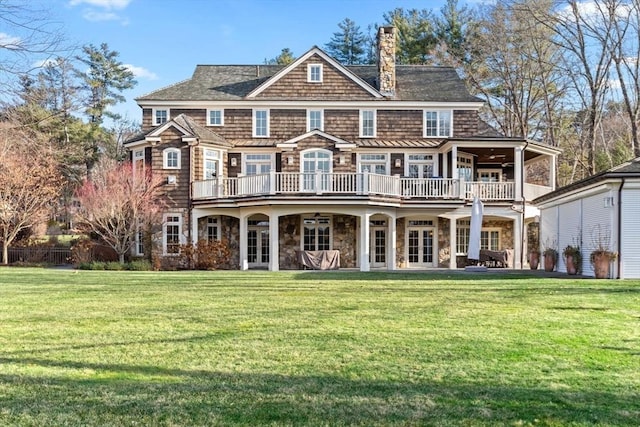 back of property with a wooden deck, a lawn, french doors, and a chimney