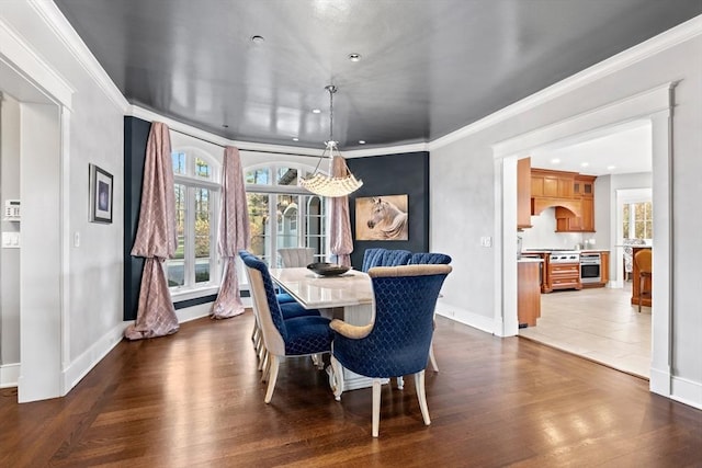 dining room with baseboards, dark wood-type flooring, and crown molding