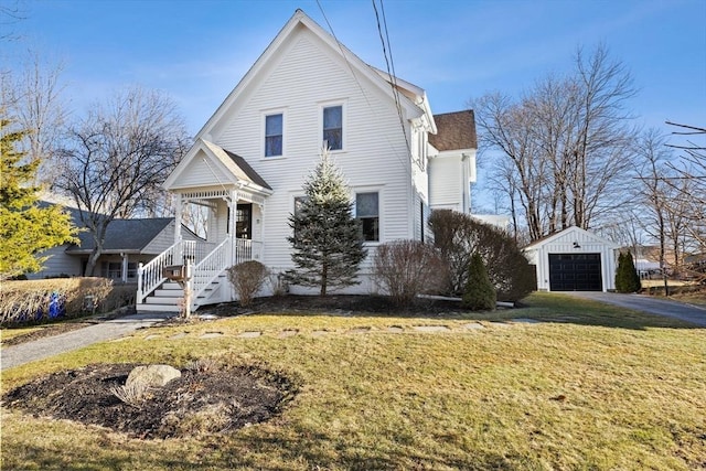 traditional-style house featuring an outbuilding, a garage, a shingled roof, driveway, and a front lawn