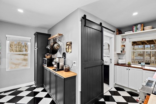 kitchen featuring light floors, a barn door, and butcher block counters