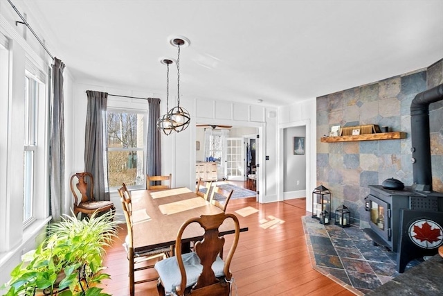 dining space featuring wood-type flooring and a wood stove