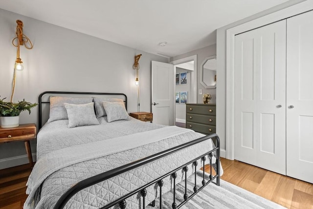 bedroom featuring wood finished floors, a closet, and baseboards