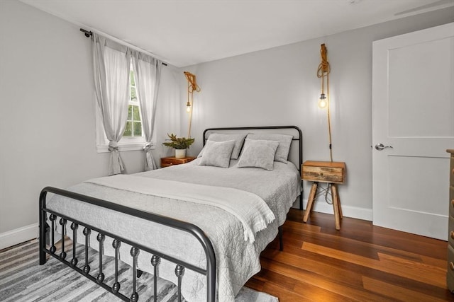 bedroom featuring baseboards and wood finished floors