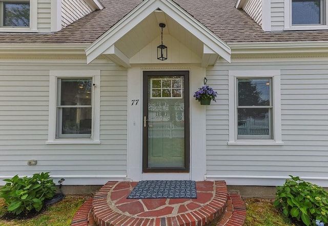 property entrance with a shingled roof