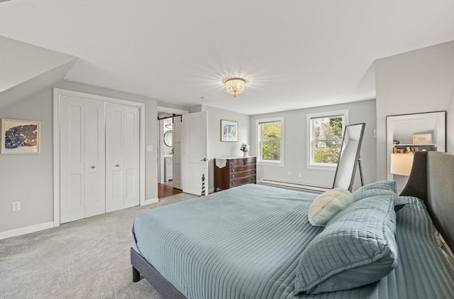carpeted bedroom featuring baseboard heating, baseboards, and a closet