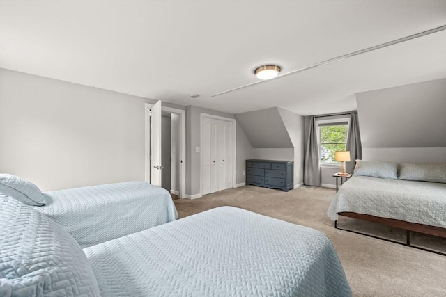 bedroom featuring light colored carpet, lofted ceiling, and baseboards