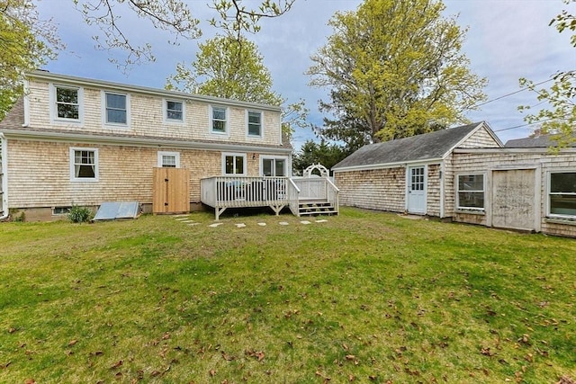 rear view of house with a wooden deck and a yard