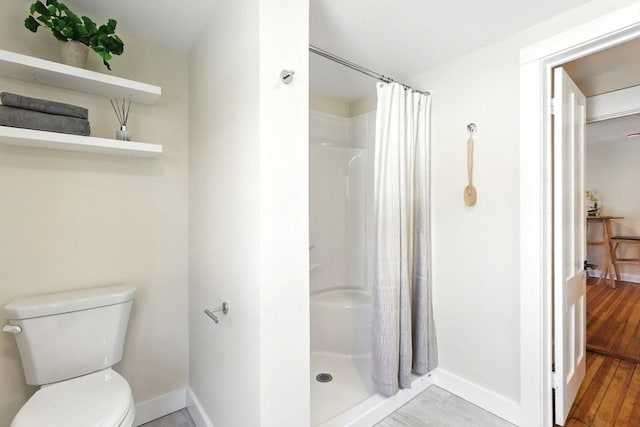 full bath with curtained shower, toilet, and wood finished floors