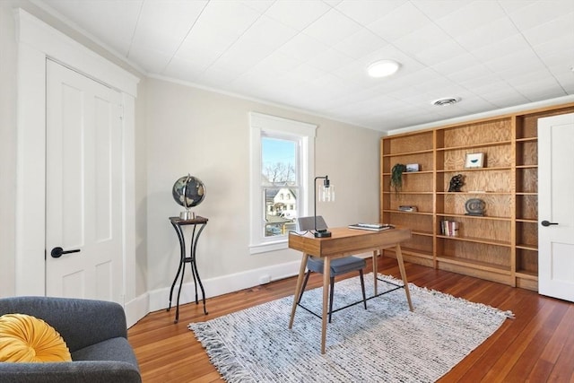 office area featuring visible vents, crown molding, baseboards, and wood finished floors