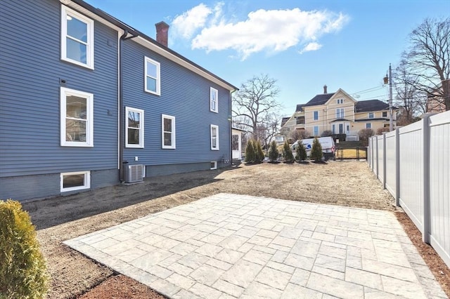 rear view of property with fence, a residential view, cooling unit, a chimney, and a patio