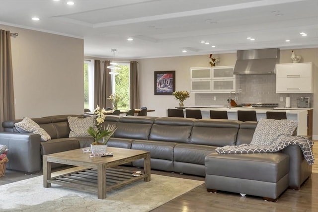 living area with crown molding, wood finished floors, and recessed lighting
