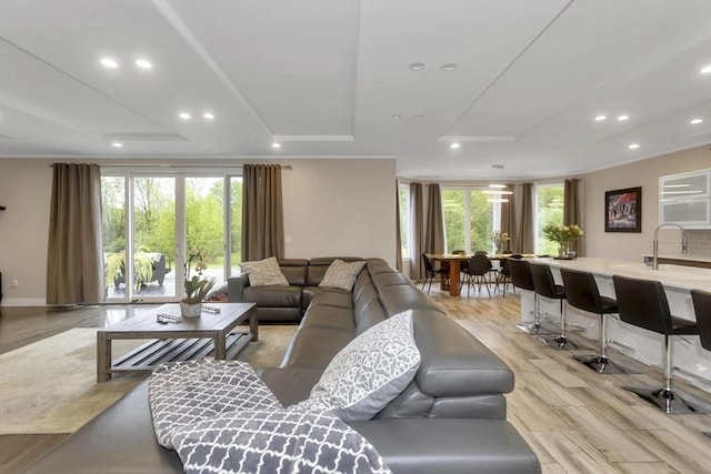 living room with healthy amount of natural light, recessed lighting, light wood-style floors, and baseboards