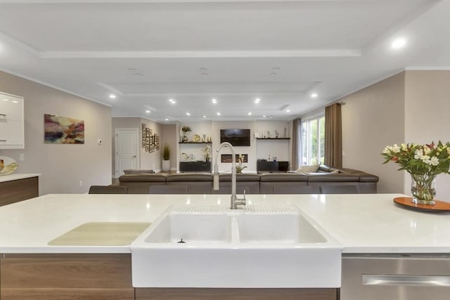 kitchen featuring open floor plan, a sink, dishwasher, light countertops, and recessed lighting