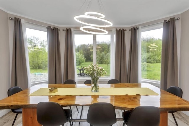 dining area with a chandelier, plenty of natural light, and crown molding
