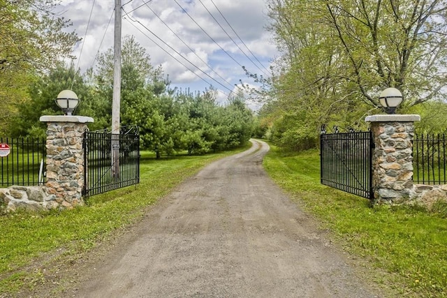 view of dirt / gravel road with a gate and a gated entry