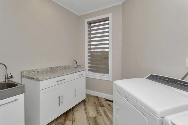 laundry area featuring cabinet space, washer and clothes dryer, baseboards, and ornamental molding