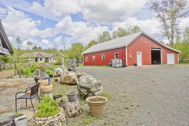 view of yard with a garage, a pole building, and an outbuilding
