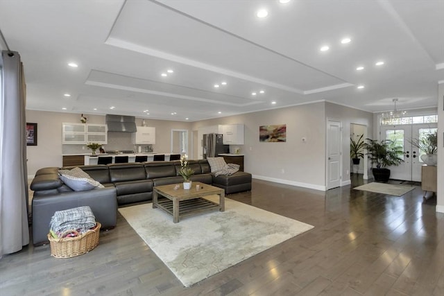 living room with a raised ceiling, baseboards, dark wood-style floors, and recessed lighting
