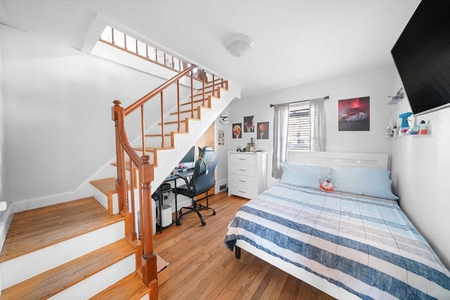 bedroom with baseboards and wood finished floors