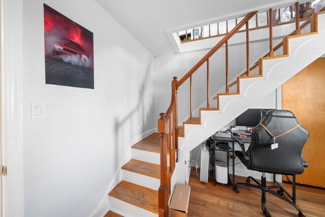 staircase with baseboards and wood finished floors