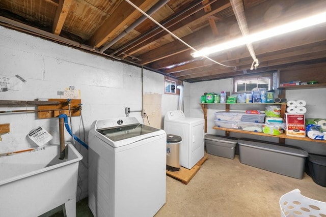 clothes washing area with laundry area, independent washer and dryer, and a sink