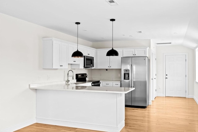 1 Pleasant St Unit 204, Cohasset, MA 02025 - kitchen featuring visible vents, light countertops, light wood-style flooring, appliances with stainless steel finishes, and a peninsula