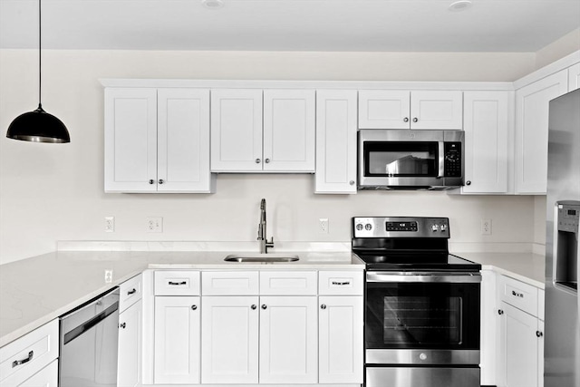 1 Pleasant St Unit 204, Cohasset, MA 02025 - kitchen with stainless steel appliances, light countertops, a sink, and white cabinetry