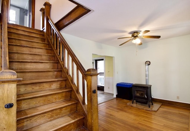 82 Worcester St, West Springfield, MA 01089 - staircase featuring hardwood / wood-style flooring, a wood stove, ceiling fan, radiator heating unit, and baseboards