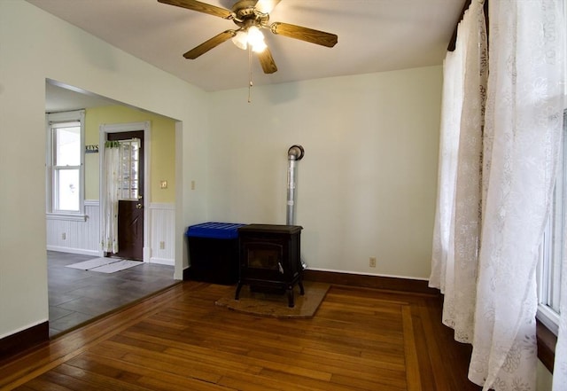 82 Worcester St, West Springfield, MA 01089 - unfurnished living room featuring hardwood / wood-style floors, a wood stove, a ceiling fan, and wainscoting